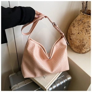 Detail of pink woven texture on large capacity shoulder bag with adjustable strap