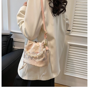 Detail of pink embroidered bucket bag with pearl handle and floral silk texture