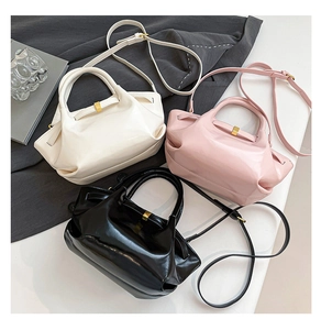 Three pleated wax leather bucket bags in cream, pink, and black with golden metal details