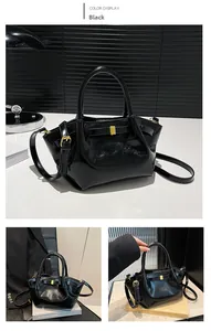 Detail view of glossy black PU leather motorcycle bag with gold buckle and strap