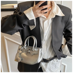 Close-up of metallic silver mini handbag with chain strap on a black blazer