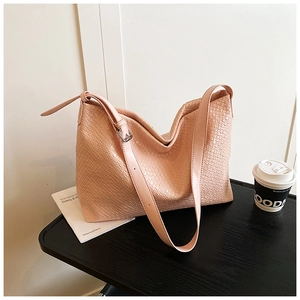 Detailed close-up of pink woven leather texture and silver buckle on a hobo tote bag