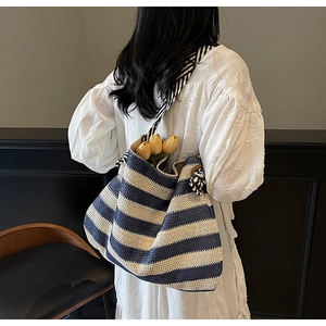 Détail du sac cabas tissé à rayures bleu marine et crème avec bandoulière en corde