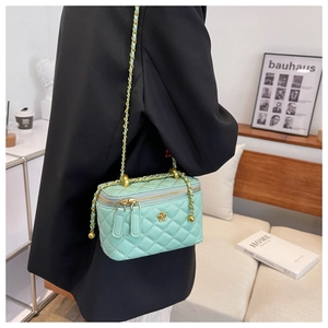 Close-up of mint green quilted PU leather box bag with gold floral hardware and chain strap