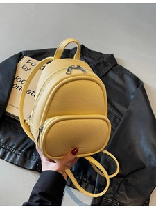 Chic yellow mini backpack in lychee leather, minimalist style for modern women travel