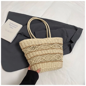 Detail view of woven straw tote bag featuring decorative diamond hollow patterns for summer
