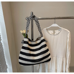 Vue détaillée du sac cabas tissé à rayures noires et blanches sur un portemanteau