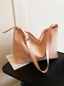Minimalist beige woven tote bag for women shown on a stylish wooden table