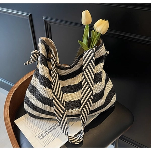Gros plan sur la texture tissée à rayures noires et blanches et le nœud du sac cabas