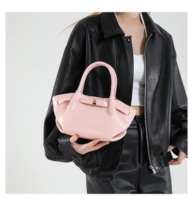 Détail du sac à main en cuir verni rose avec texture plissée et nœud décoratif
