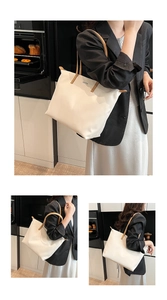 Detail view of large cream tote bag with brown straps in a modern lifestyle setting
