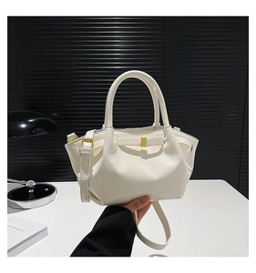 Gros plan d'un sac bandoulière en cuir PU blanc avec un nœud décoratif et détails dorés