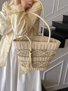 Large hand-woven straw tote bag with tassel charm and wood beads for summer beach vacations