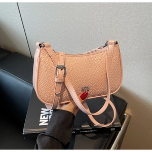 Detail of pink faux crocodile leather underarm bag with silver logo and adjustable strap