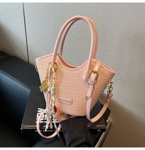 Pink woven texture bucket bag with gold hardware and decorative knot accessory