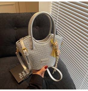 Detailed silver woven bucket bag featuring gold tennis racket charm and silk scarf handle