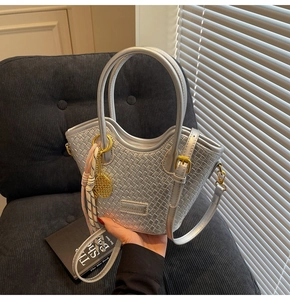 Detailed silver woven bucket bag with tennis racket charm and floral scarf detail