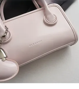 Detail of light pink PU leather bowling bag showing CLEAROK logo and heart charm