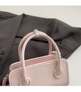 Detail of pink PU leather bowling bag showing rounded handles and silver metal hardware