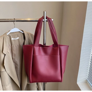 Detail view of burgundy tote bag with matte leather finish and precision stitching
