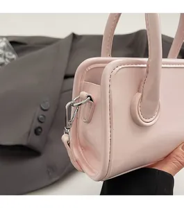 Detail shot of the silver metal hardware and smooth pink leather on the small square bag