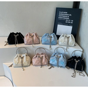 Detailed display of four colorful butterfly embroidered bucket bags with pearl tassels