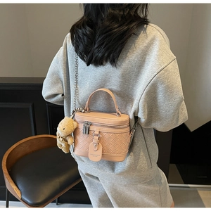 Detailansicht der rosa geflochtenen Box-Tasche mit Silberkette und süßem Bären-Anhänger