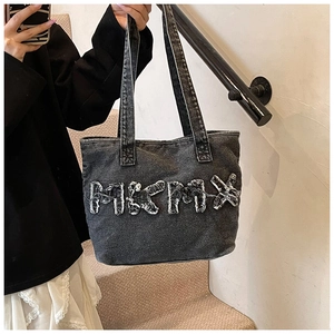 Close-up of MIKMIX letter patch and distressed denim texture on grey tote bag