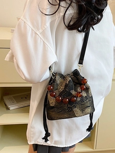 Modern Chinese bucket bag with golden butterfly embroidery and beaded handle strap