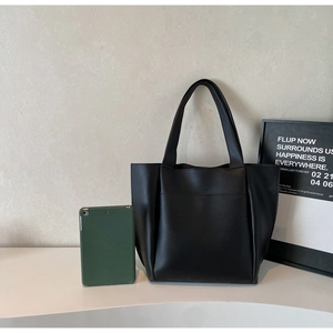 Black matte leather tote bag detail with tablet showing the large storage capacity