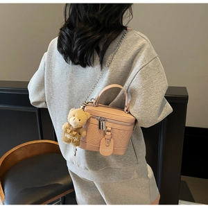 Detailansicht der rosa geflochtenen Zylindertasche mit Kette und Bärenanhänger