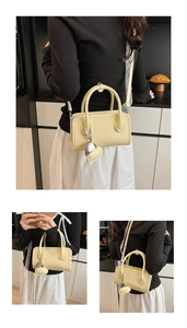 Detail of butter yellow crossbody bag with heart pendant and brand logo engraving