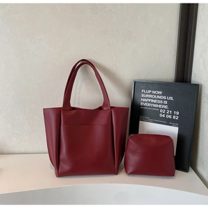 Macro shot of dark red leather tote bag showing large front pocket and stitching details