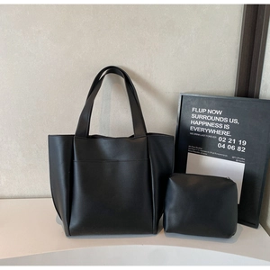 Close-up of minimalist black tote bag set with matching zipper pouch in premium matte leather