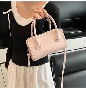 Detail of pink fashion handbag featuring silver metal hardware and clear brand logo