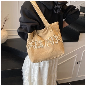 Lifestyle view of mustard yellow vintage washed denim tote bag with letter patchwork