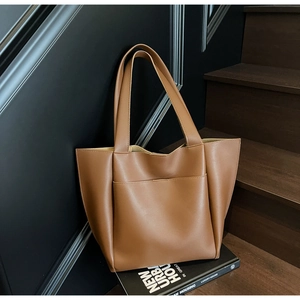 Caramel brown tote bag with smooth leather texture and wide shoulder strap for work