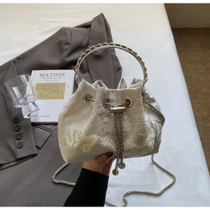 Detailed close-up of butterfly embroidery and lace fabric on drawstring bucket bag