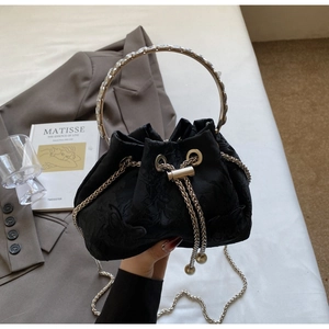 Detail of black jacquard bucket bag with crystal handle and silver chain strap