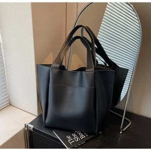 Macro shot of minimalist black tote bag texture with large front compartment