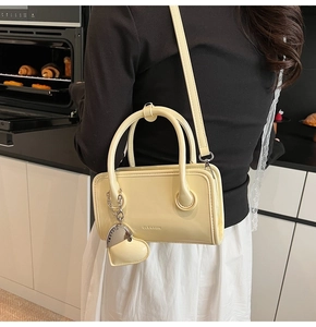 Detail shot of cream yellow leather crossbody bag with CLEAROK branding in a home setting