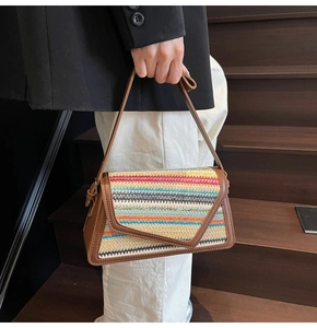Détail d'un sac en paille tissé coloré avec bordure et bandoulière en cuir marron