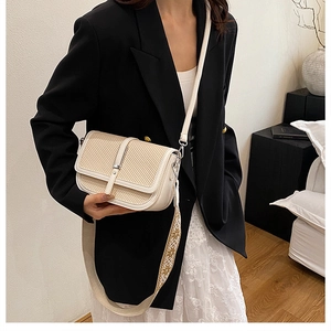 Detail of vintage beige woven crossbody bag with stylish ethnic pattern wide strap