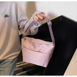 Sac seau en nylon rose avec bandoulière réglable et détails de rivets argentés