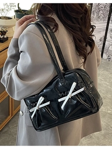 Minimalist black patent shoulder bag with white bows and dual front gusset pockets