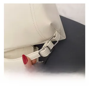 Detail of adjustable strap with silver buckle on minimalist cream leather backpack