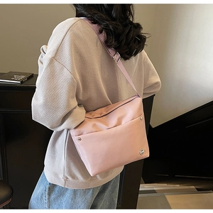 Gros plan détaillé d'un sac seau en nylon rose avec bandoulière réglable pour femme