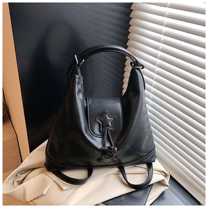 Detail of black PU leather backpack with star patch and buckle on white blazer background