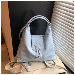 Detail of light blue faux leather backpack tote with star patch and drawstring closure