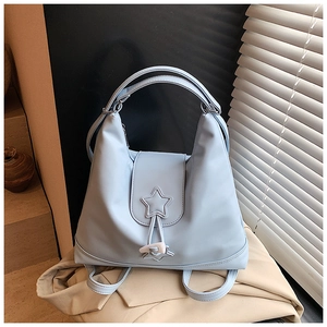 Detail view of light blue nylon backpack showing star stitching and toggle closure